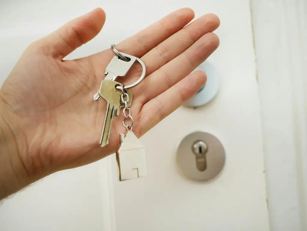 Hand with house key representing investment property advisor